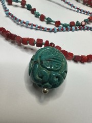 handmade red coral and turquoise beaded necklace with a carved green cinnabar