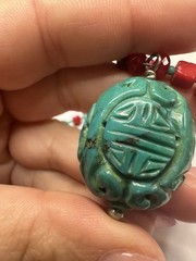 handmade red coral and turquoise beaded necklace with a carved green cinnabar