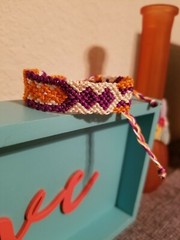 Eye catching beige/orange/purple adjustable tie macrame bracelet.