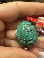 handmade red coral and turquoise beaded necklace with a carved green cinnabar