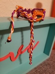 Eye catching beige/orange/purple adjustable tie macrame bracelet.