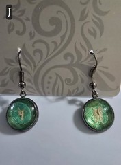 Handcrafted Dangle Earrings. Green and gunmetal. Empress tree seed behind glass.
