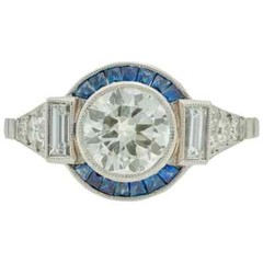 Features A Central 1.13CT Round European Cut CZ With Blue Sapphire Art Deco Ring