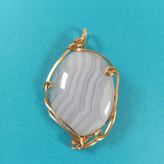 Gold tone wire wrapped white banded glass cabochon pendant unsigned 2 1/2″ tall
