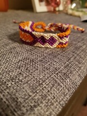 Eye catching beige/orange/purple adjustable tie macrame bracelet.