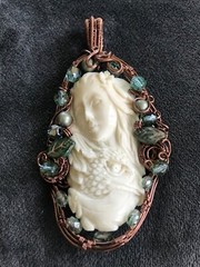 Wire wrapped carved pendant of woman w/eagle & fish; framed with beads